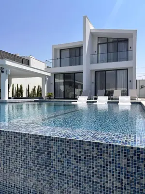 a swimming pool in front of a house at Shomani by Seahorse in Al Rama