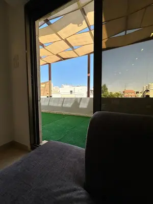a bedroom with a window with a view of a green field at Rooftop pool with terraces F-R in Amman