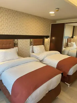 a hotel room with two beds and a mirror at Londrina Hotel in Amman