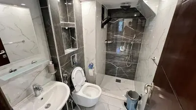 a bathroom with a toilet and a sink and a shower at شقة مفروشة فخمة بغرفتين نوم عمو سامي in Amman