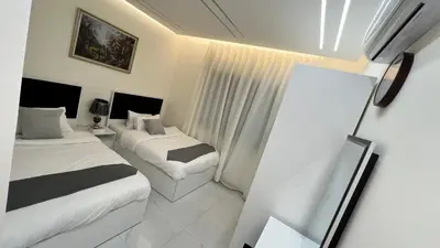 a hotel room with two beds and a mirror at شقة مفروشة فخمة بغرفتين نوم عمو سامي in Amman