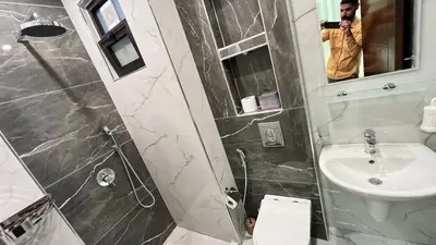 a man taking a picture of a bathroom at شقة مفروشة فخمة بغرفتين نوم عمو سامي in Amman