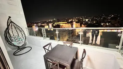 a balcony with a table and chairs and a view at شقة روف بعرفتين اطلالة ساحرة عمو سامي 21 in Amman