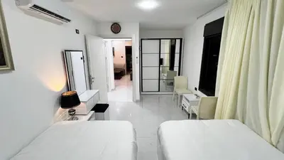 a white room with two beds and a mirror at شقة روف بعرفتين اطلالة ساحرة عمو سامي 21 in Amman