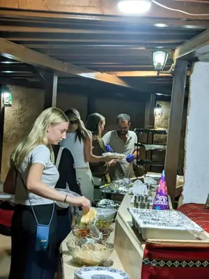 a group of people standing in a kitchen preparing food at Desert Sand Camp in Disah