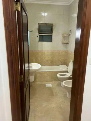 a bathroom with two toilets and a tub and a sink at olga 300 apertment in Ar Ramthā