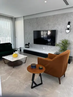 a living room with a couch and a tv at Beit Elhala Villa By Seahorse in Al Rama