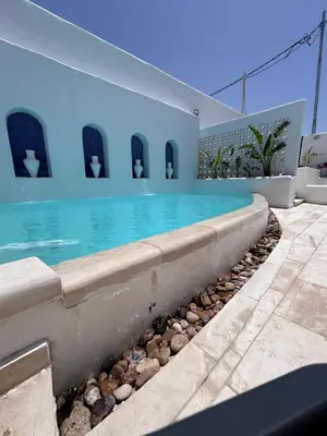 a swimming pool in the middle of a house at The Greek Village - Paros By Seahorse in Sowayma