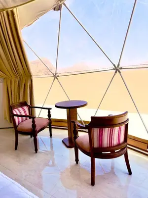 a room with two chairs and a table and a window at Hkaya Rum camp in Wadi Rum