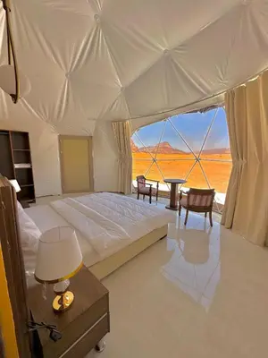 a bedroom with a bed with a view of the desert at Hkaya Rum camp in Wadi Rum