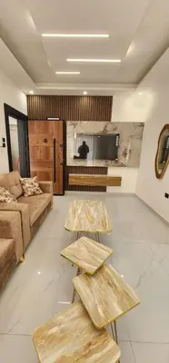 a living room with two tables and a couch at شقة مفروشة بغرفتين نوم وصالة و حمامين in Amman
