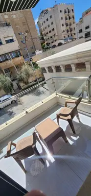 a patio with two chairs and a table on a roof at شقة مفروشة بغرفتين نوم وصالة و حمامين in Amman