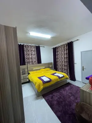 a bedroom with a yellow bed with a purple rug at Jarash in Jerash