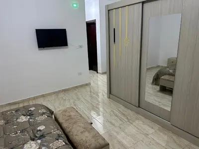 a living room with a couch next to a sliding door at Airport Road شارع المطار in Al Yādūdah