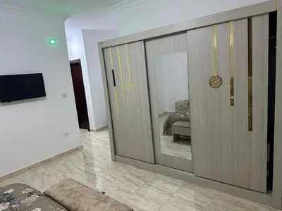 a room with a sliding glass door with a bedroom at Airport Road شارع المطار in Al Yādūdah
