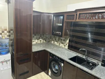 a kitchen with a sink and a washing machine at Airport Road شارع المطار in Al Yādūdah