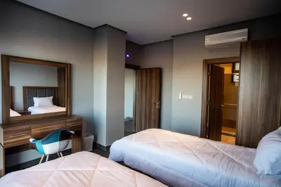 a bedroom with two beds and a desk and a mirror at Makanak Villas in Jerash