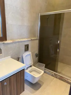 a bathroom with a white toilet and a shower at Makanak Villas in Jerash