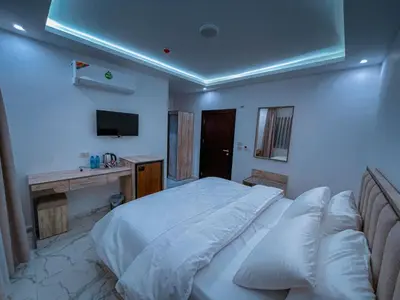 a bedroom with a large white bed and a desk at Petra Friends House in Petra