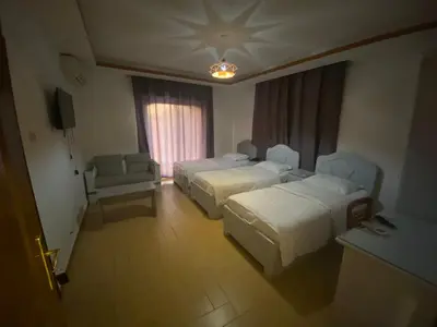 a hotel room with two beds and a couch at فندق اربد بلازا in Irbid
