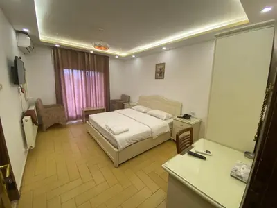 a hotel room with a bed and a desk and a room at فندق اربد بلازا in Irbid