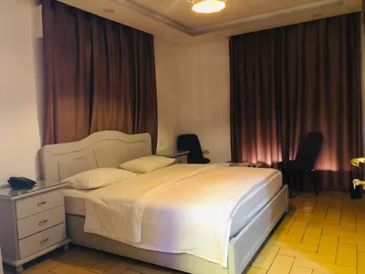a bedroom with a large white bed and two chairs at فندق اربد بلازا in Irbid