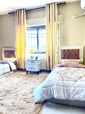 a bedroom with a bed and a window at Classy 3 Bedroom Apartment in Amman in Ţāb Kirā‘