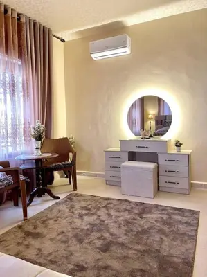 a living room with a table and a mirror at Classy 3 Bedroom Apartment in Amman in Ţāb Kirā‘