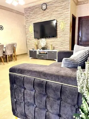 a living room with a couch and a flat screen tv at Classy 3 Bedroom Apartment in Amman in Ţāb Kirā‘