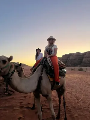 two people riding on a camel in the desert at Magic mountains rum in Wadi Rum