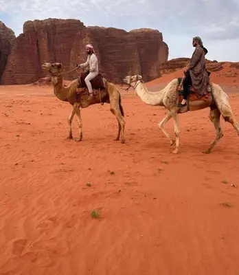 two people riding on camels in the desert at Wadi rum magical in Wadi Rum