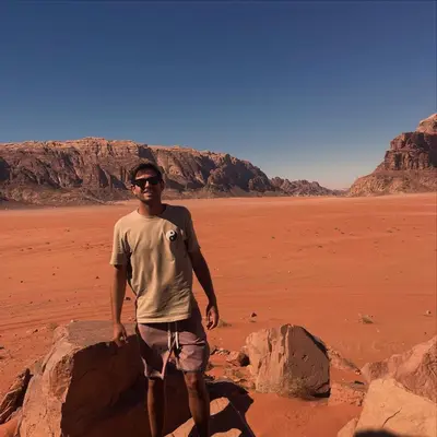 a man standing next to a rock in the desert at Wadi rum magical in Wadi Rum