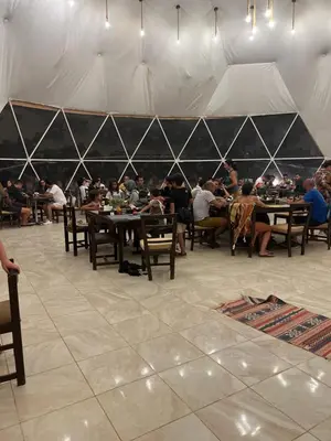 a group of people sitting at tables in a tent at RADISSON lUXURY RUM CAMP in Wadi Rum