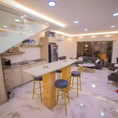 a kitchen with a counter and stools in a room at Jumeirah Chalet جميرا شاليه in Amman