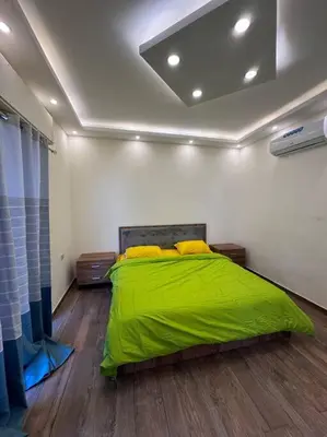 a bedroom with a green bed in a room at Jumeirah Chalet جميرا شاليه in Amman