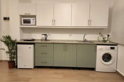a kitchen with a sink and a washing machine at Goga Apartment in Jabal Amman near Rainbow Street in Ash Shumaysānī