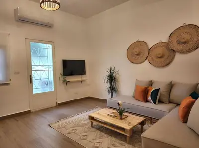 a living room with a couch and a coffee table at Goga Apartment in Jabal Amman near Rainbow Street in Ash Shumaysānī