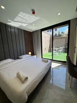 a bedroom with a large bed and a large window at Chic Apartments For Rent ave0-2 in Umm Uthainah