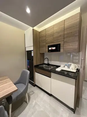 a kitchen with a counter and a sink and a table at Chic Apartments For Rent ave0-2 in Umm Uthainah