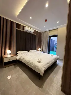 a bedroom with a large bed with two night stands and two lamps at Chic Apartments For Rent ave0-3 in Amman