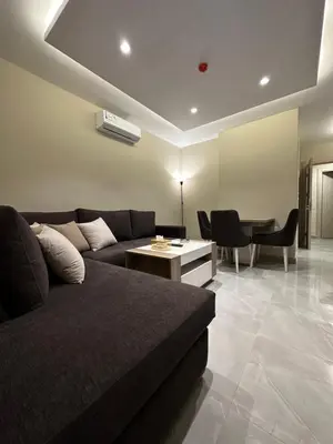 a living room with a couch and a table at Chic Apartments For Rent ave0-4 in Umm Uthainah