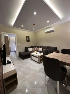 a living room with a couch and a table at Chic Apartments For Rent ave0-4 in Umm Uthainah