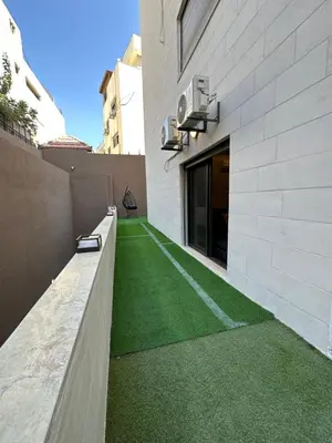 an internal courtyard of a building with green grass at Chic Apartments For Rent ave0-5 in Amman