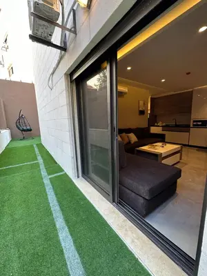 a house with a fake grass floor in a living room at Chic Apartments For Rent ave0-5 in Amman