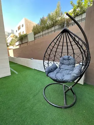 a swing chair sitting on top of a yard at Chic Apartments For Rent ave0-5 in Amman