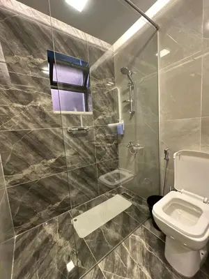 a bathroom with a toilet and a glass shower at Chic Apartments For Rent ave0-5 in Amman