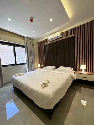 a bedroom with a large bed with two towels on it at Chic Apartments For Rent ave0-6 in Amman