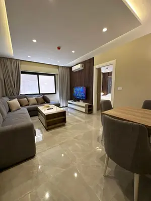 a living room with a couch and a table at Chic Apartments For Rent ave0-7 in Umm Uthainah