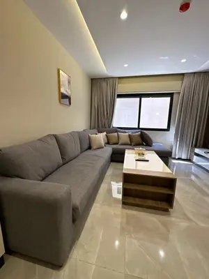 a living room with a couch and a coffee table at Chic Apartments For Rent ave0-7 in Umm Uthainah