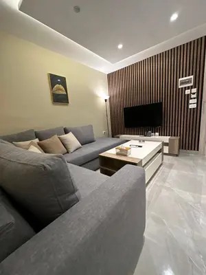 a living room with a couch and a tv at Chic Apartments For Rent ave0-8 in Umm Uthainah